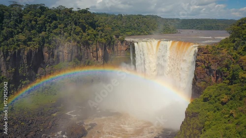 Kaieteur Falls, Guyana Dramatic shot of Kaieteur Falls plunging from a high plateau into deep jungle, rainbow forming in the mist, cinematic style 