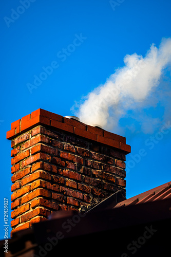 Smoke from the chimney of a single-family house