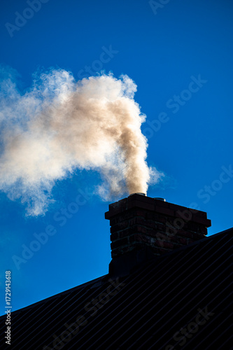 Smoke from the chimney of a single-family house