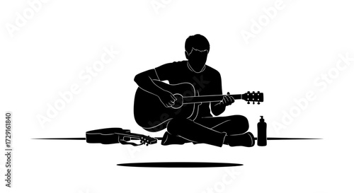 Musician plays acoustic guitar outdoors with second guitar and bottle beside him