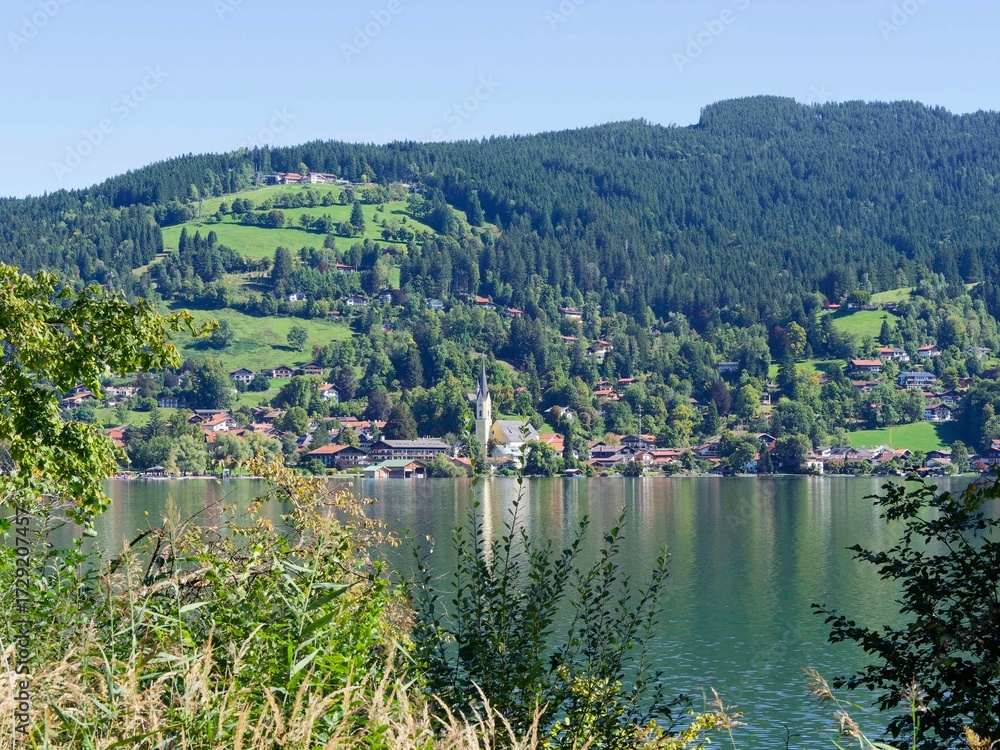 Fototapeta premium City of Schliersee and St. Sixtus Church in the district of Miesbach (Upper Bavaria Germany) northeast of lake Schliersee at foot of meadows and wooded slopes of Rohnberg (Schliersberg) 