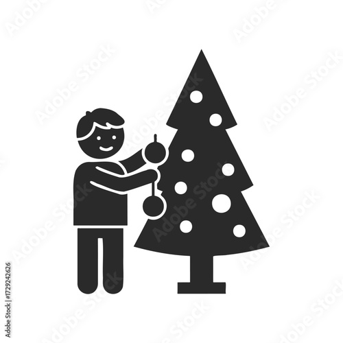 Silhouette of child decorating christmas tree with baubles