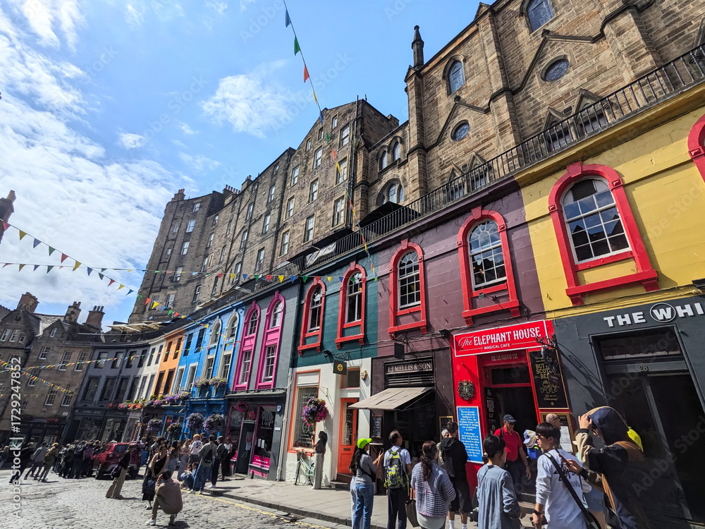 Naklejka premium Crowds of tourists on the colorful curved Victoria Street in Edinburgh's historic Old Town