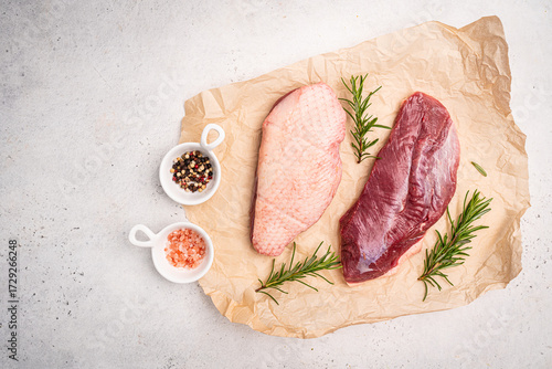 Preparation for cooking raw duck breast with ingredients on white background, top view. Space for text. High quality photo
