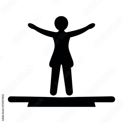 Silhouette of a person standing with arms outstretched on a balance beam in a gym