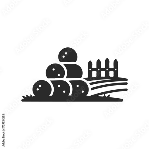 Silhouette of hay bales and fence on farm landscape