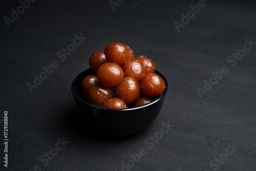 A Gulab jamun in sugar syrup pool, luxury dessert