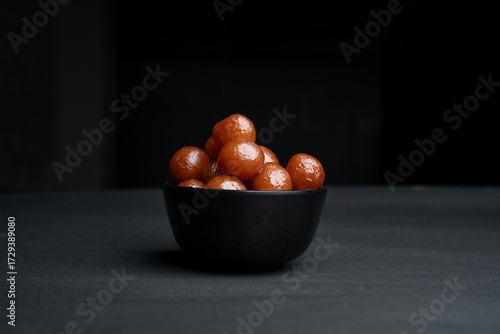 A bowl full of gulab jamun in sugar syrup pool, luxury dessert
