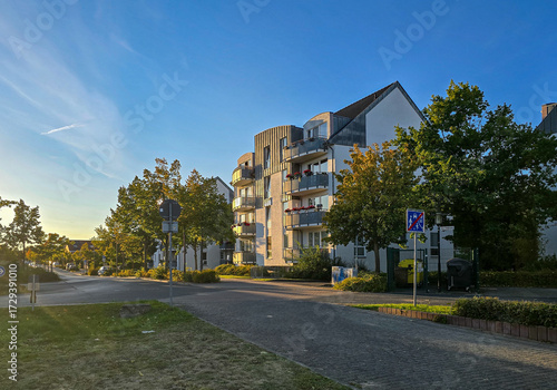 Photos modern residential building with multiple balconies stands along a quiet street in the warm evening light
