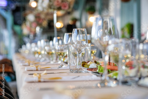glasses on the table. wedding table setting.  close-up of elegant wine glasses on a long banquet table set for a luxury wedding or fine dining event with shallow depth of field