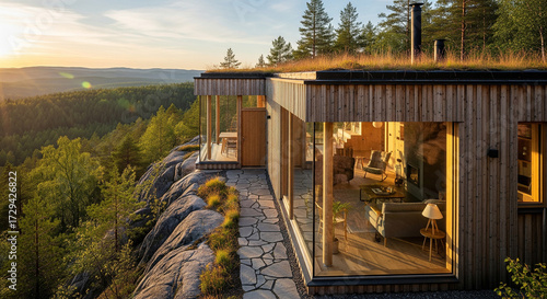 Modern eco-friendly wooden house with a living roof on a rock formation, offering breathtaking views of a serene forest landscape bathed in the warm glow of sunset, showcasing sustainable architecture
