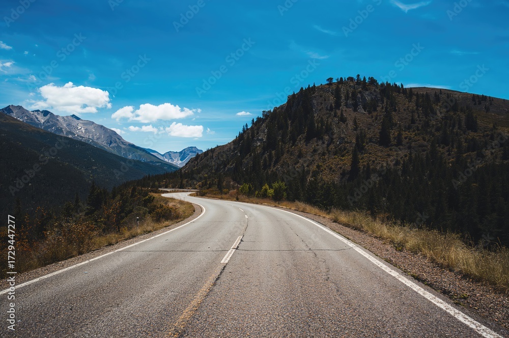 Fototapeta premium Deserted highway and mountain landscape beneath a clear blue sky