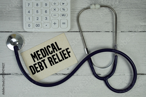 Medical Debt Relief text with Stethoscope and calculator on wooden background