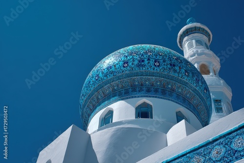 Beautifully decorated mosque minaret with intricate blue tilework and Islamic architecture, standing tall under a vivid, cloudless sky.