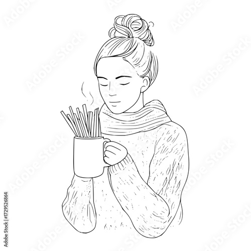 Woman with hair in a bun wearing a sweater and scarf holding a mug filled with sticks steaming up close