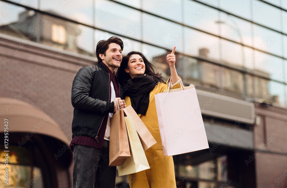 © Prostock-studio - Beautiful couple shopping together in the city, walking with paper bags © Prostock-studio - Beautiful couple shopping together in the city, walking with paper bags