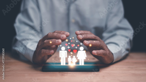 Family protection concept. Businessman hands covering digital icons of parents and children on smartphone. Symbolizing health insurance, safety, love, care and security for happy family life.
