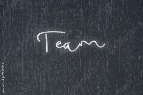 A blackboard with a handwritten chalk message that says team, a powerful symbol of business success and motivation in educational and production concepts.