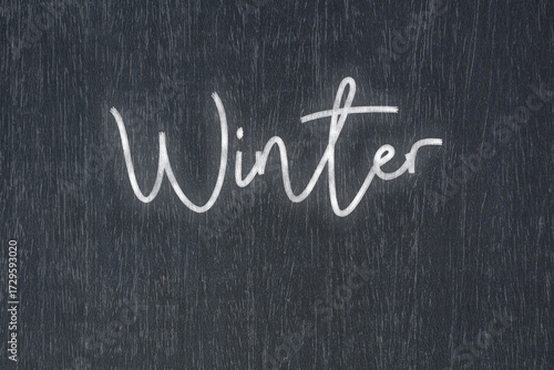 A blackboard with a handwritten chalk message that says winter, a powerful symbol of business success and motivation in educational and production concepts.
