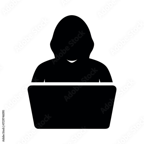 Silhouette of a hooded figure working on a laptop computer in a dark setting