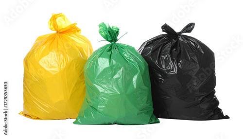Collection of three vibrant yellow, green, and black plastic garbage bags, full of household waste, highlighting proper disposal and environmental sustainability efforts