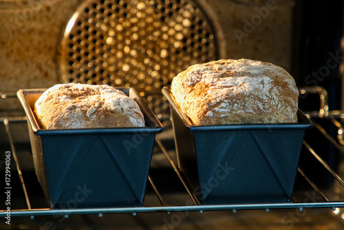 Two loaves of spelt bread cooking in an electric oven.