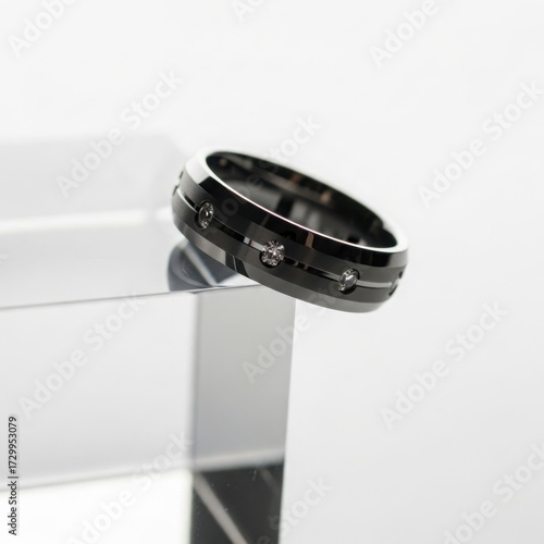 Stacked black tungsten wedding bands on a clear acrylic block with dynamic shadows, featuring a bold and contemporary jewelry mockup.