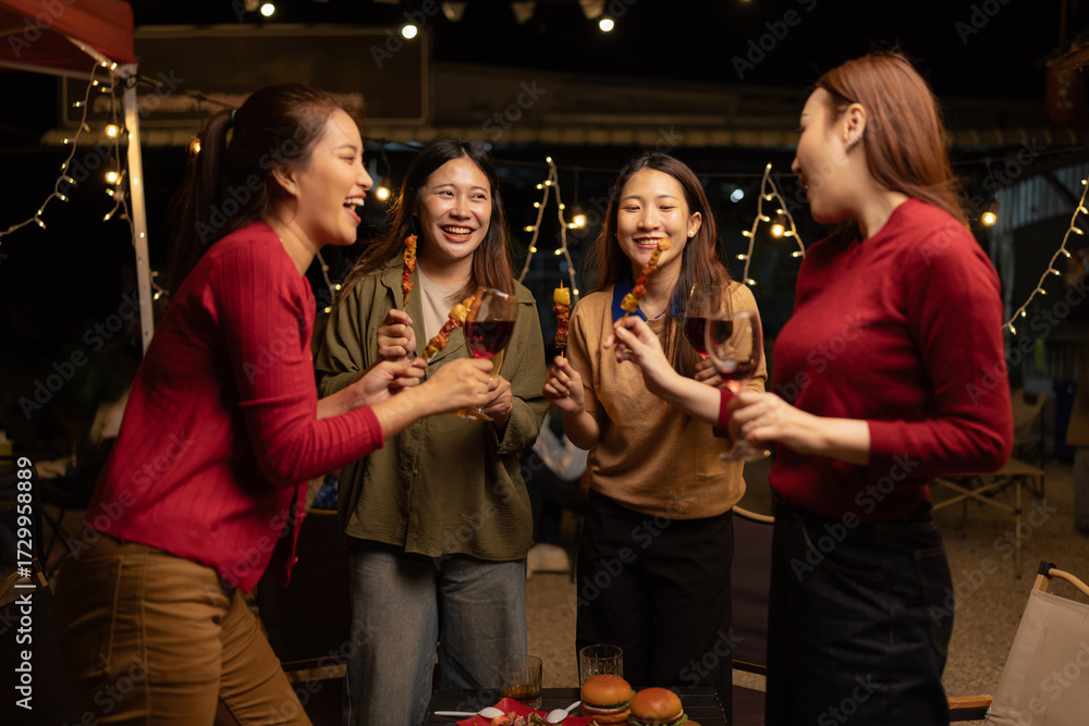 Fototapeta premium Happy Group of Woman Friends Celebrating Together at Night, Сlinking glasses of dinner at a social gathering.