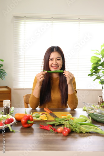 Happy young woman preparing healthy food in the kitchen.