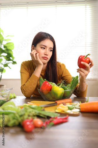 Healthy Eating Headaches Concept. A woman looks stressed with fruits and vegetables on table in room at home.