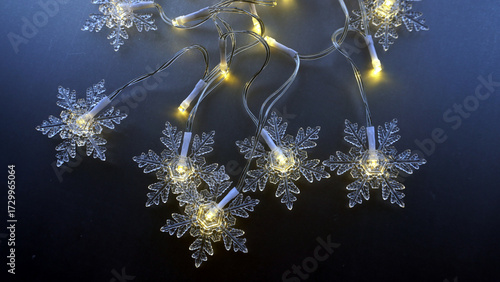 A string of Christmas lights shaped like snowflakes. Dark blue background. Christmas festive atmosphere