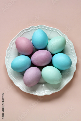 Pastel dyed easter eggs on white plate celebrating spring