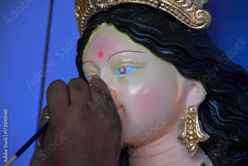 An artiest has been drawing and painting eyes of goddess Durga. Clay idol of Hindu goddess Durga is under preparation.