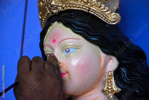 An artiest has been drawing and painting eyes of goddess Durga. Clay idol of Hindu goddess Durga is under preparation.