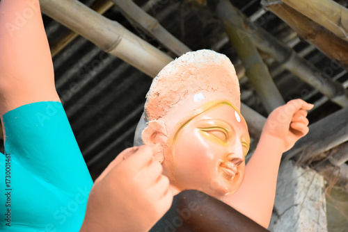 An artiest has been drawing and painting eyes of goddess Durga. Clay idol of Hindu goddess Durga is under preparation.