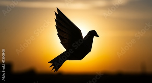 Silhouette of a paper dove in flight against a sunset sky symbolizing peace and hope