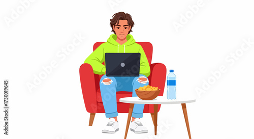 A young man in a green hoodie and ripped jeans sits comfortably in a red armchair, engrossed in his laptop, with a bowl of snacks and a water bottle on a nearby table.