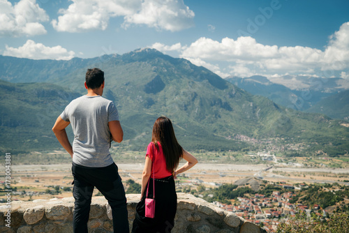 Картината върху платно Couple standing on a stone viewpoint overlooking the vast valley and mountains near Meteora, Greece
