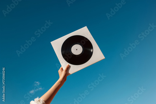 One hand holding the vinyl cover of the music album