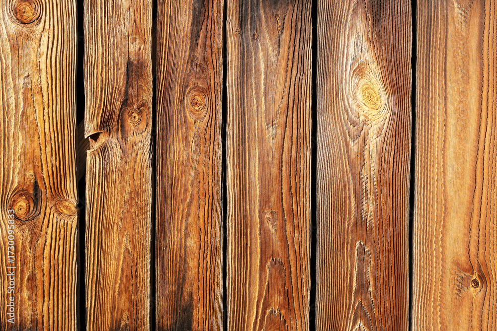 Naklejka premium Wooden planks background texture. Brown wood surface closeup. Rustic timber detail. Natural construction material. Old wooden boards for design. Outdoor architecture element.