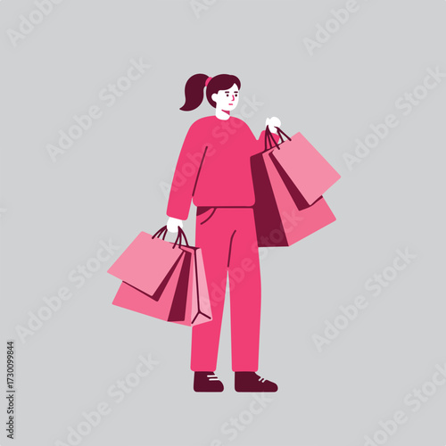 Pink-suited woman holding shopping bags on grey background