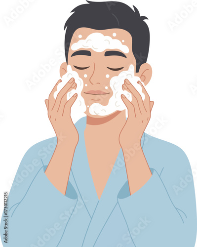 A man in a robe washes his face with foamy cleanser, eyes closed, enjoying the process.