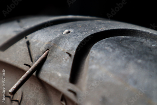 Canvas Print Close up A motorbike tubeless tire that is stuck in iron nails, this can cause a leak and must be repaired immediately
