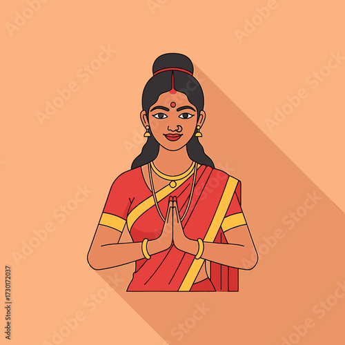 Woman in traditional Indian attire with hands in Namaste gesture, smiling warmly.