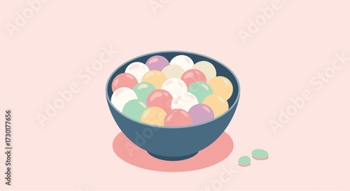 A bowl filled with colorful mochi balls sitting on a pastel pink background.