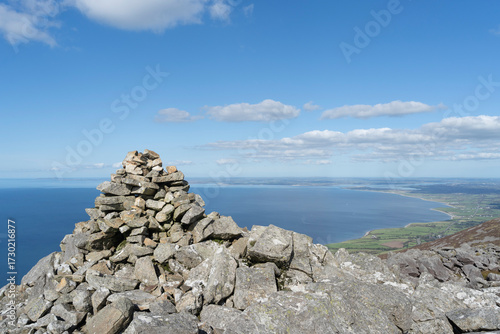 Summit cairn on Gyrn Ddu mountain with views over Caernarfon Bay, Gwynedd, Wales, UK