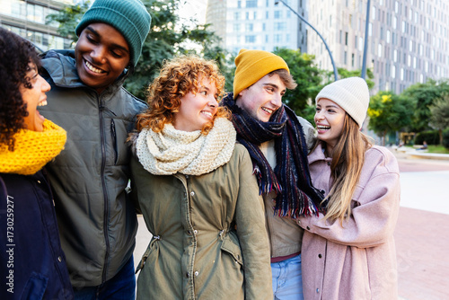 Wallpaper Mural Cheerful diverse friends exploring urban streets on a cold winter day, bundled in cozy clothes. Friendship and winter lifestyle concept. Torontodigital.ca