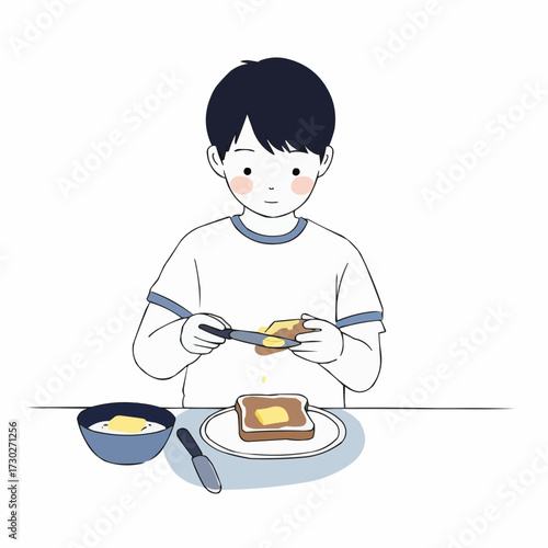 Young boy spreading butter on toast while sitting at the table  