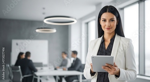 Professional Woman in Modern Office Holding Tablet.