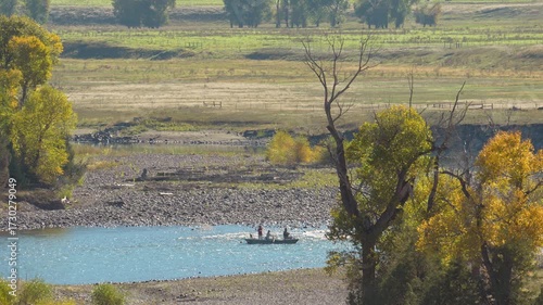 Anglers in Autumn Light Float by Golden Willow Trees in Montana